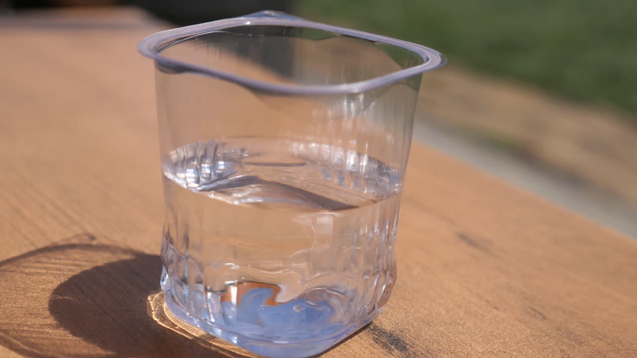 나무 테이블에 물의 유리입니다.