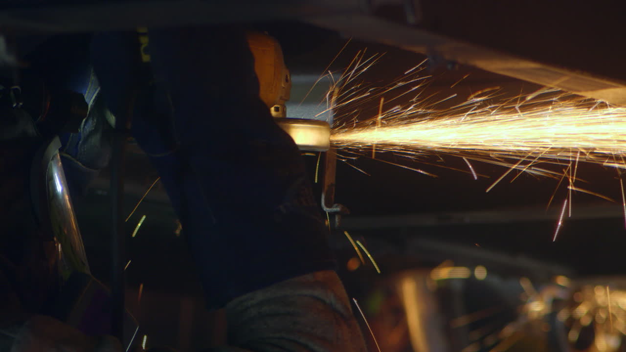 trabajador de la industria lima piezas de metal con una sierra circular, generando chispas espectaculares