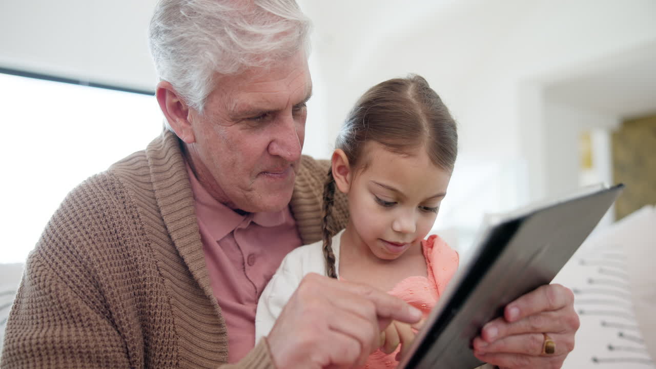 Nonno, bambina e tablet per casa.