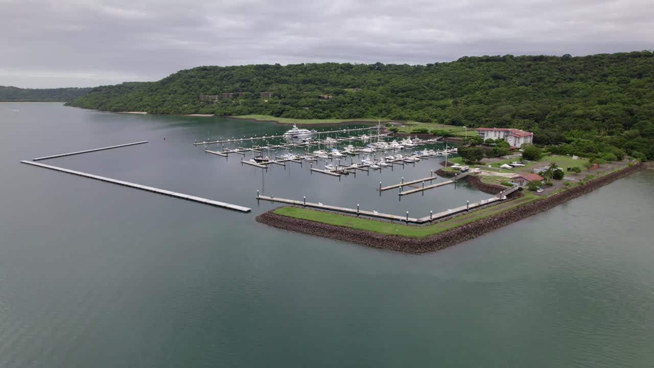 나카스콜로 해변, 파파가요 반도, 코스타리카에서 흐린 날 부두에 있는 보트의 왼쪽 공중 트럭, 숲 언덕 근처의 청록색 바다