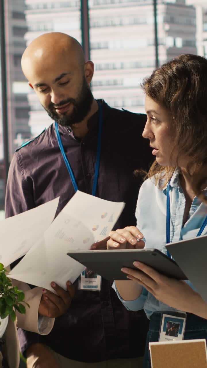 Vertical video Coworkers in office doing brainstorming, reviewing financial charts