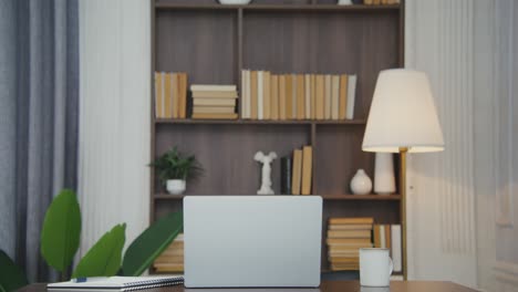 home office workspace with laptop and bookshelf