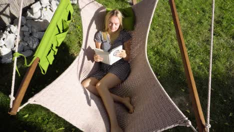 Joven-Rubia-Hermosa-Adolescente-Leyendo-En-Una-Hamaca-Durante-Las-Vacaciones