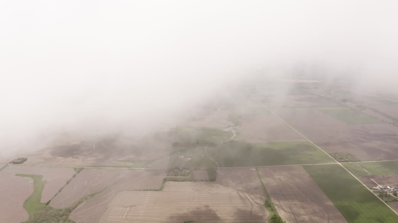 드론은 미국 중서부의 초원과 농지 위의 구름을 통과합니다.