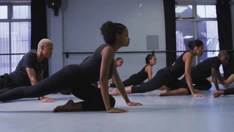 multi-ethnic group of fit male and female modern dancers practicing a dance routine