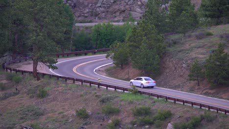 Aerial-view-of-automobile-going-through-a-tight-curve-in-the-mountains