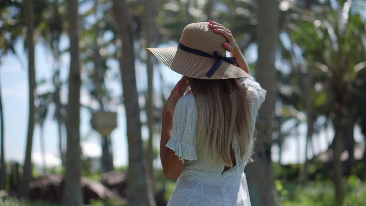 Woman in a dress walking through a tropical forest