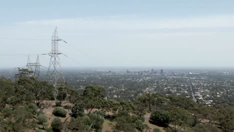 Coches-Que-Viajan-Por-La-Carretera-En-La-Colina-Con-El-Paisaje-Urbano-De-Adelaide-En-El-Fondo-En-Australia