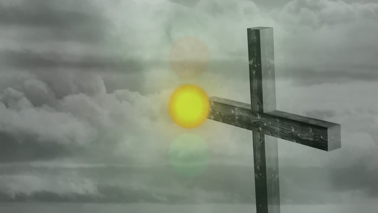 Bright sun shining through clouds behind wooden cross standing against sky