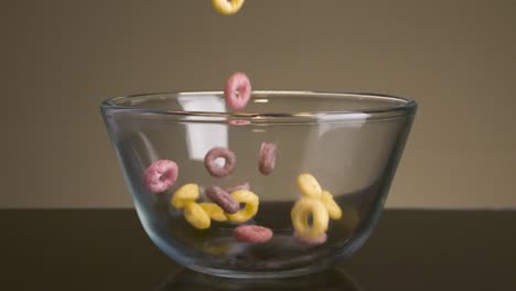 colorful cereal pouring into a glass bowl