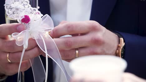 groom holding champagne flute with wedding rings