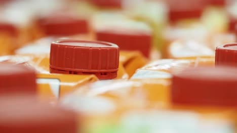 close-up of red caps on orange beverage cartons