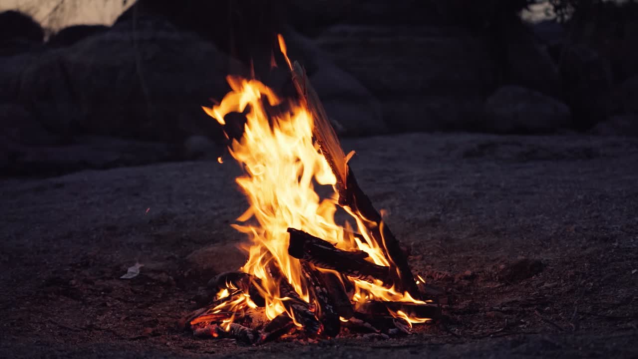 Slow motion of fire at bonfire in the dark, closeup