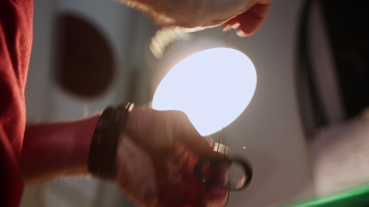 taller de cuero - un hombre cosía un bucle de cinturón de cuero con una aguja gruesa