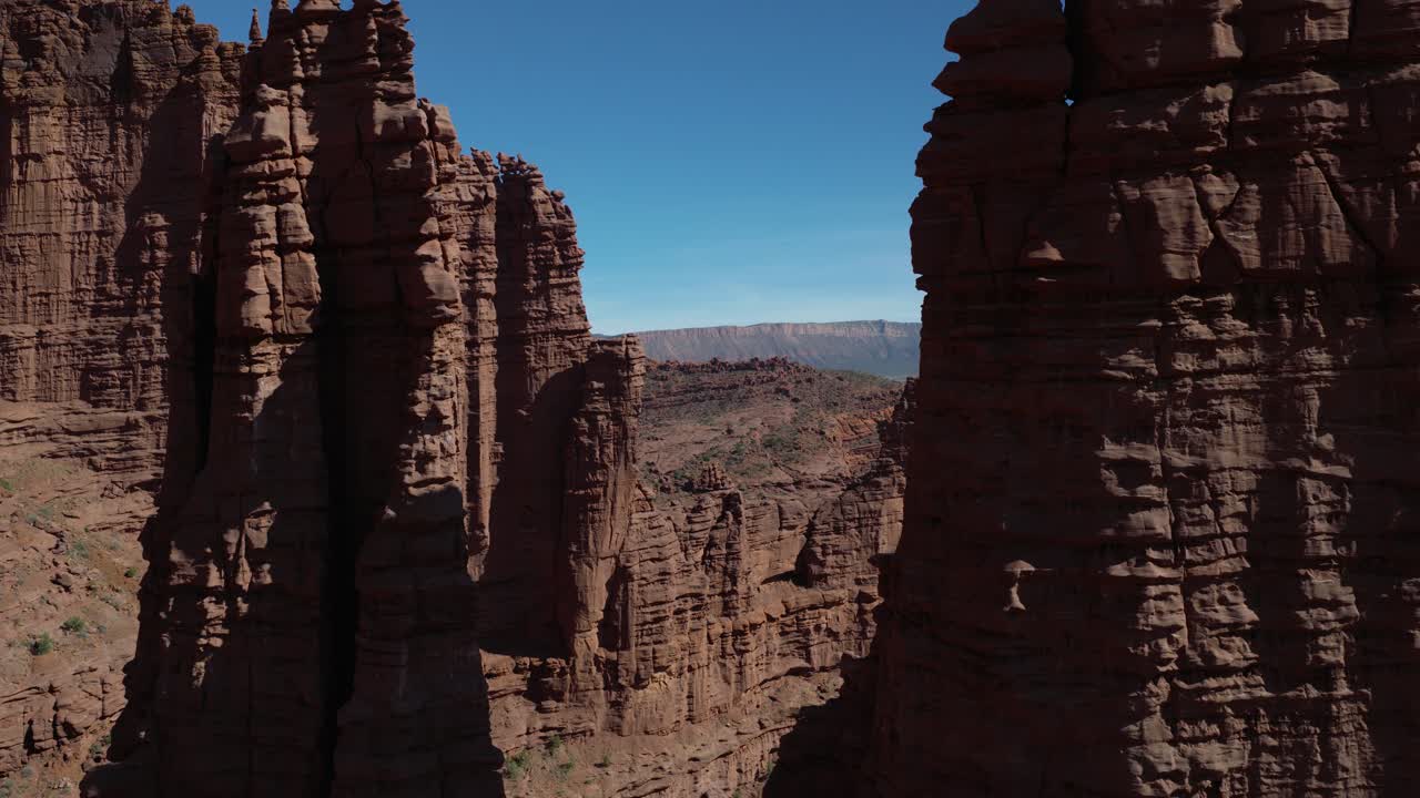 Ripresa aerea in allontanamento delle spettacolari guglie delle Fisher Towers, arenaria Cutler rosso scuro sormontata da strati Moenkopi.