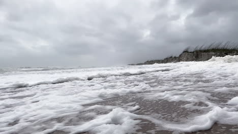 Wind-Bläst-Meeresschaum-über-Den-Strand-In-Dünen,-Als-Hurrikan-Nicole-An-Land-Kommt