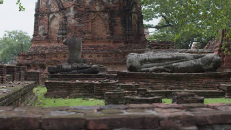 buddha statue among ruins of the wat mahathat in ayutthaya