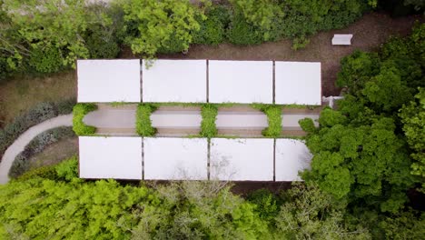 vista aérea de un jardín blanco con arcos de plantas verdes, grandes paneles de tela blanca para protegerse de la lluvia o el sol, ideal para una ceremonia de boda