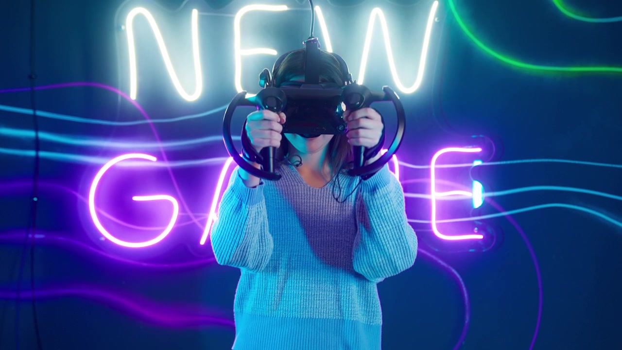 Giovane donna che gioca a un gioco di realtà virtuale con luci al neon