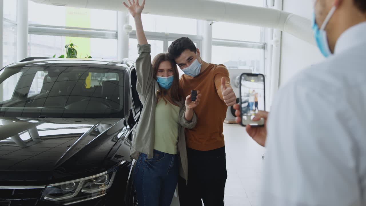 una pareja feliz con las llaves de un coche nuevo.