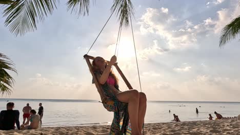 girl swinging under a palm tree in the maldives, ocean view, thodoo island