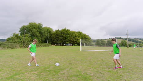 male soccer players training, warming up and practicing passing ball in pairs on pitch