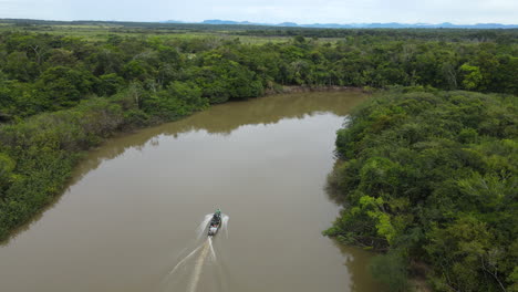 Drone-Shot-of-Motorboat-Sailing-in-Rupununi-River,-Amazon-Basin,-Rural-Guyana-South-America,-Tracking-Aerial-View