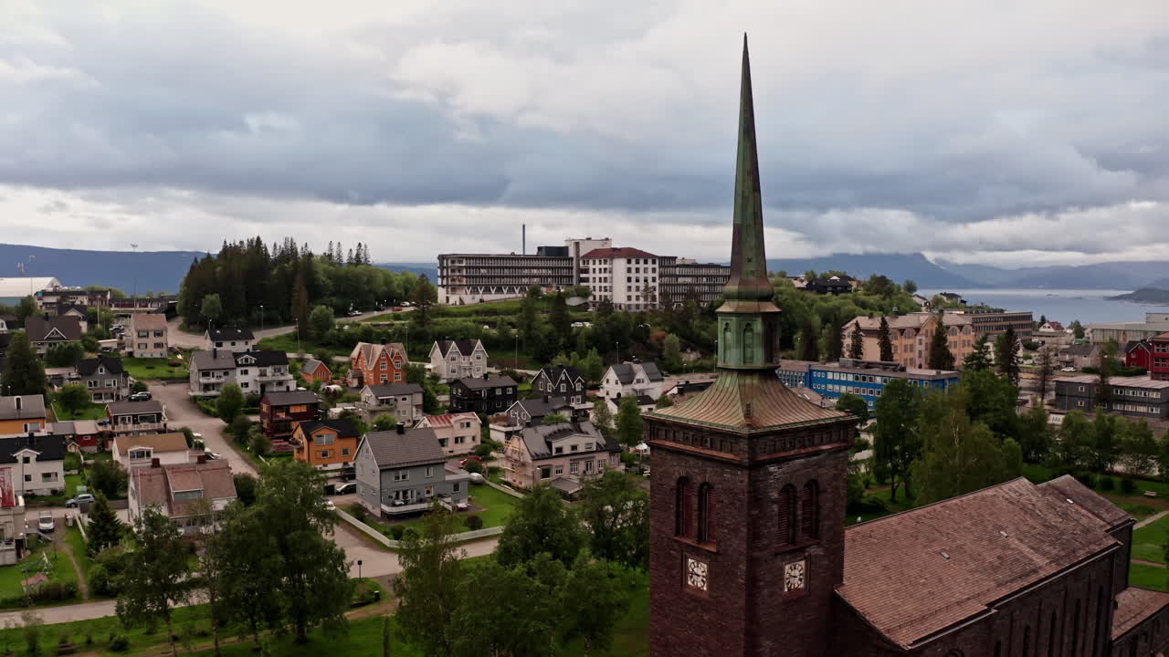 Aerial drone shot over the city of Narvik in Norway. High view of the local church, houses and buildings of the nordic town.