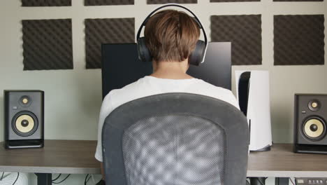 Boy-Laying-down-his-PS5-controller-and-headset-then-walking-away-after-gaming-on-his-PlayStation-5-in-the-afternoon,-Wide