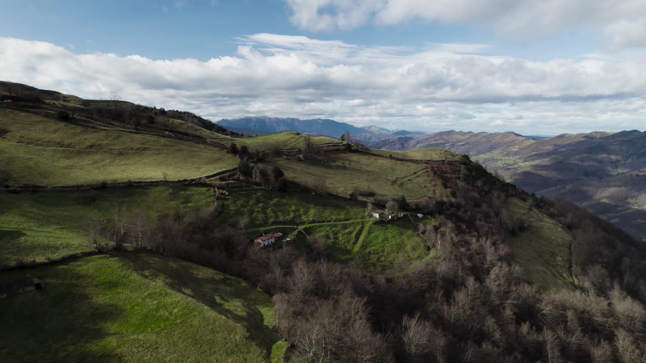 Volando sopra fattorie costruite su alti altopiani erbosi in cima a una catena montuosa.