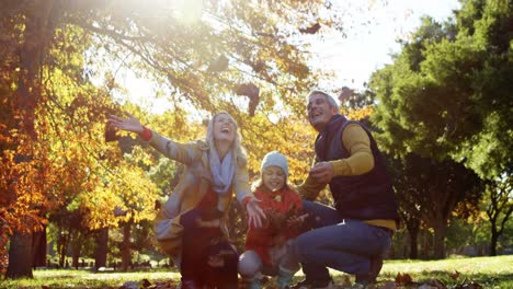 mother-dad-and-daughter-throwing-leaves-outdoors