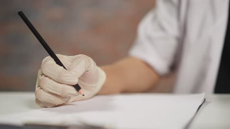 medical student writes on paper with pencil in hospital