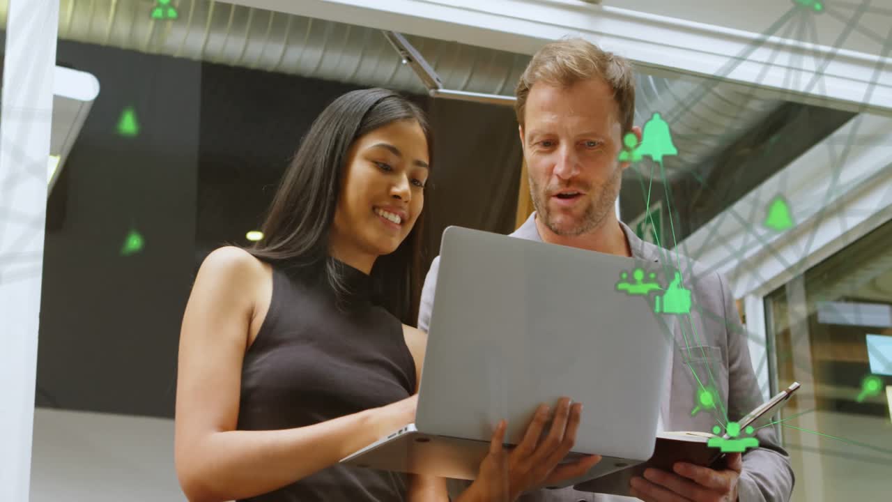 animación de iconos de computadoras conectadas que forman un globo sobre diversos compañeros de trabajo analizando datos en la computadora portátil