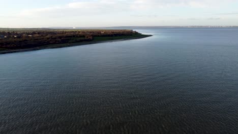 Coastal-Aerial-of-a-shore-village-in-Isle-of-Grain,-British-Coast,-United-Kingdom