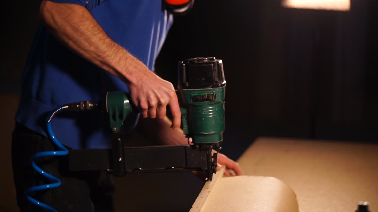 Man using a nail gun to install foam board