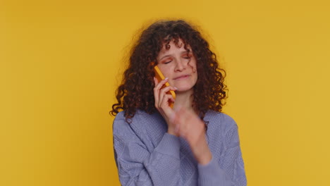 Young-woman-tired-sleepy-freelancer-talking-on-mobile-phone-with-friend-making-online-conversation