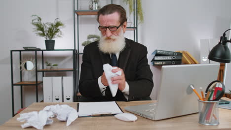 angry furious man working at home office throwing crumpled paper, having nervous breakdown at work
