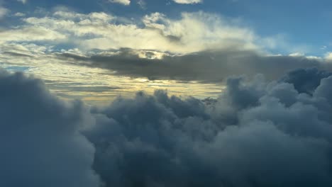 aerial view from a jet cockpit, pilot point of view during a flght through winter clouds at sunset