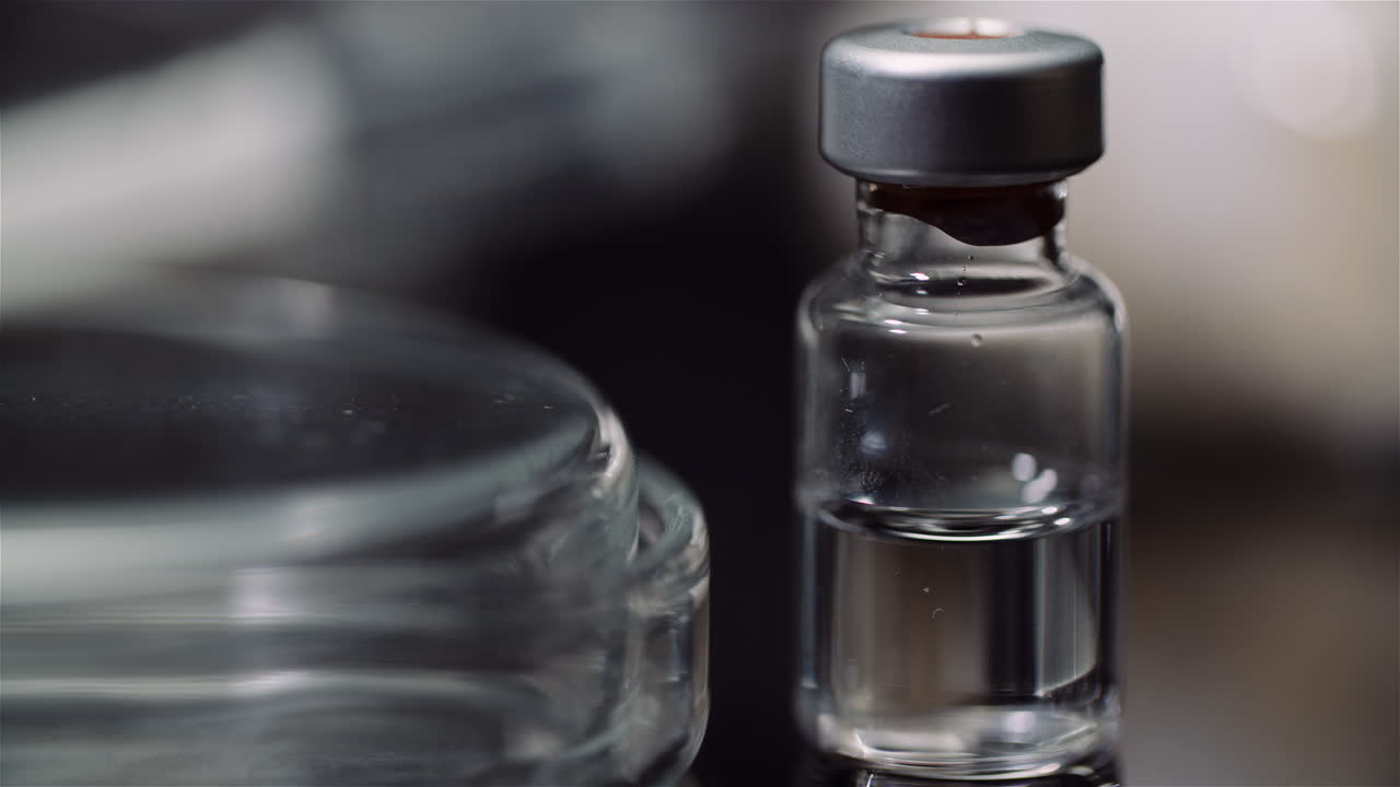 Gros plan sur un flacon médical et une boîte de Pétri en laboratoire