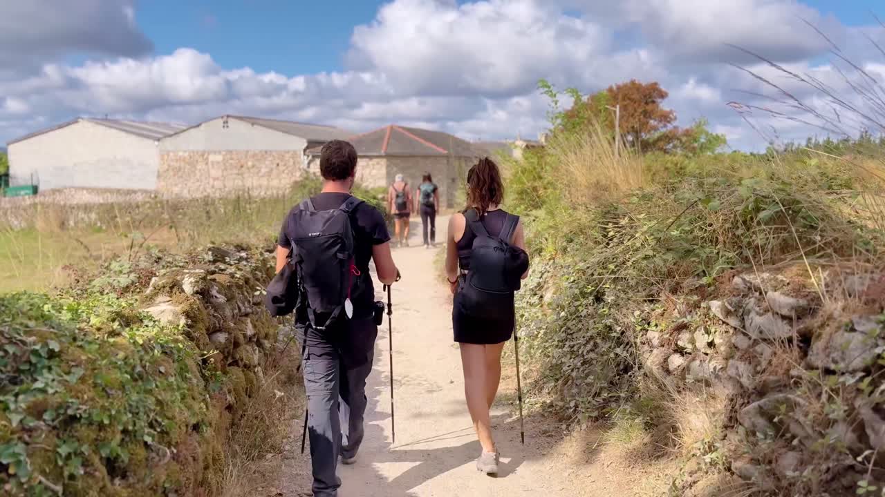 Group of people walking the Camino de Santiago in Spain, experiencing pilgrimage, culture, and spiritual journey through scenic rural landscapes