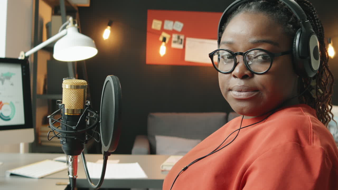 Portræt af afroamerikansk kvindelig podcaster i hjemmestudie