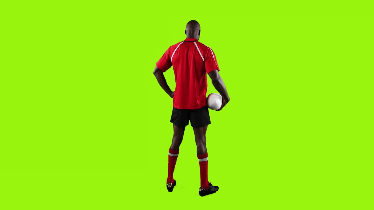 프로 럭비 선수 가 서서 초록색 배경 에 공 을 들고 있다 4k