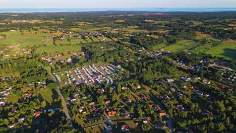 view of different houses surrounded by green trees on a sunny day in sweden - aerial shot