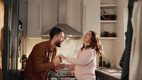 pareja feliz bailando en la cocina