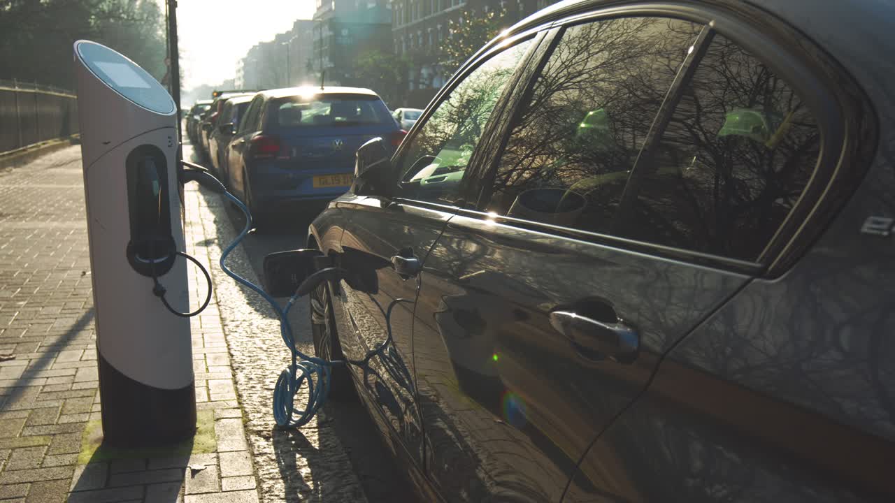 un vehículo eléctrico estacionado cargando en un punto de carga al aire libre en la ciudad.