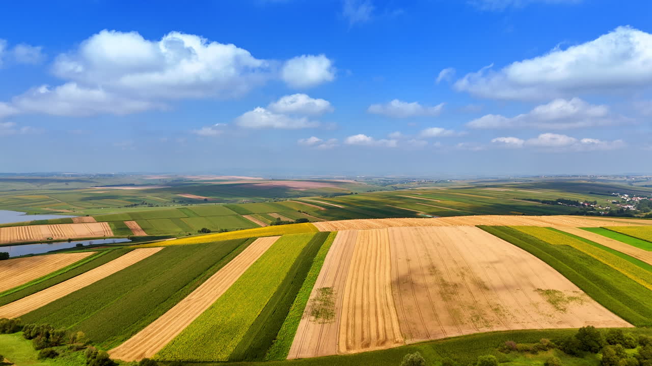 Patchwork fields in the Romanian countryside. Colorful agricultural fields stretch across the plains of Romania, viewed from above on a clear summer day