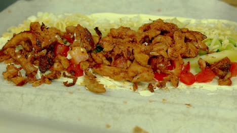 cu cook prepares shawarma with cheese chicken french fries cucumber tomatoes