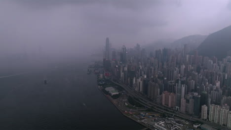 aerial wide shot of heavy thunderstorm and lightning strike over hong kong island during cloudy and rainy day