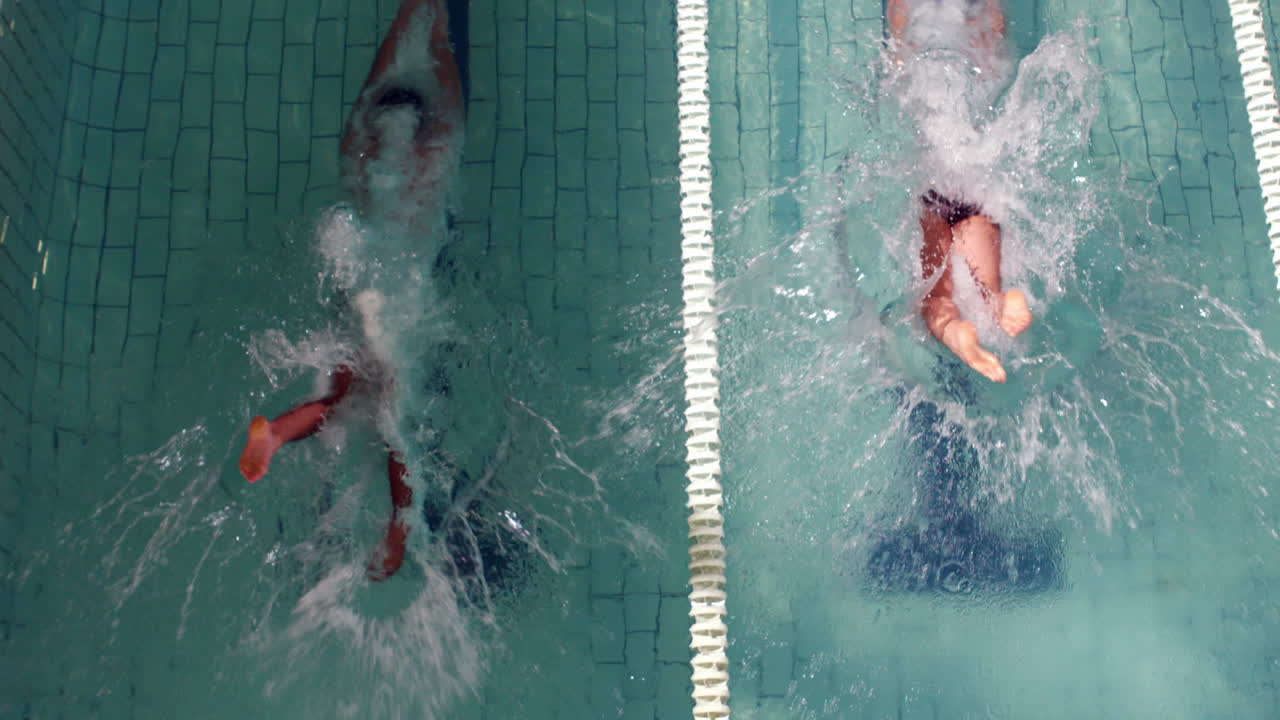 Above view of swimmers diving into pool