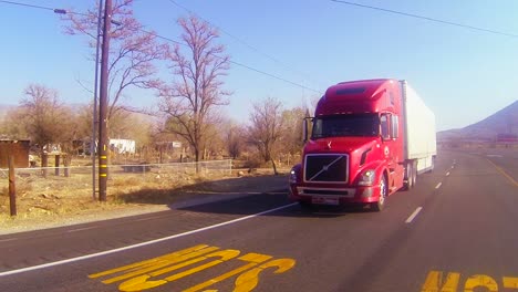 A-red-18-wheeler-truck-moves-across-the-desert-in-this-POV-shot-1